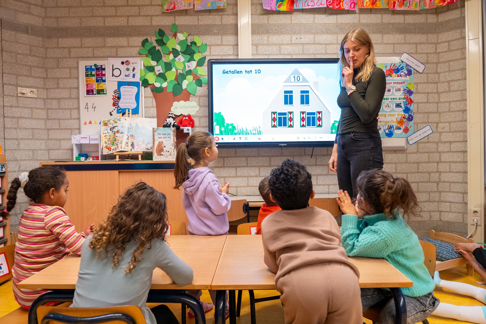 Leerkracht bij digibord in klas